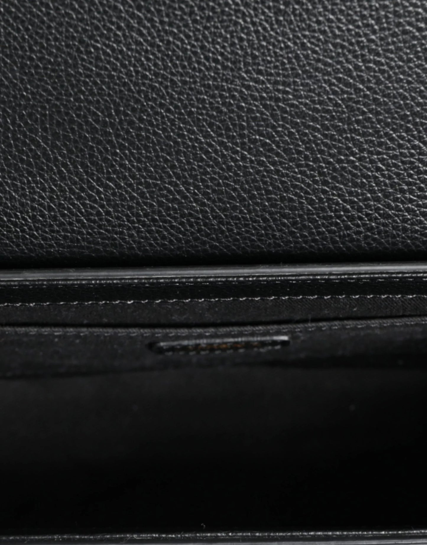 Close-up of premium black textured leather, detail of designer fashion accessory at ONJEL Boutique.