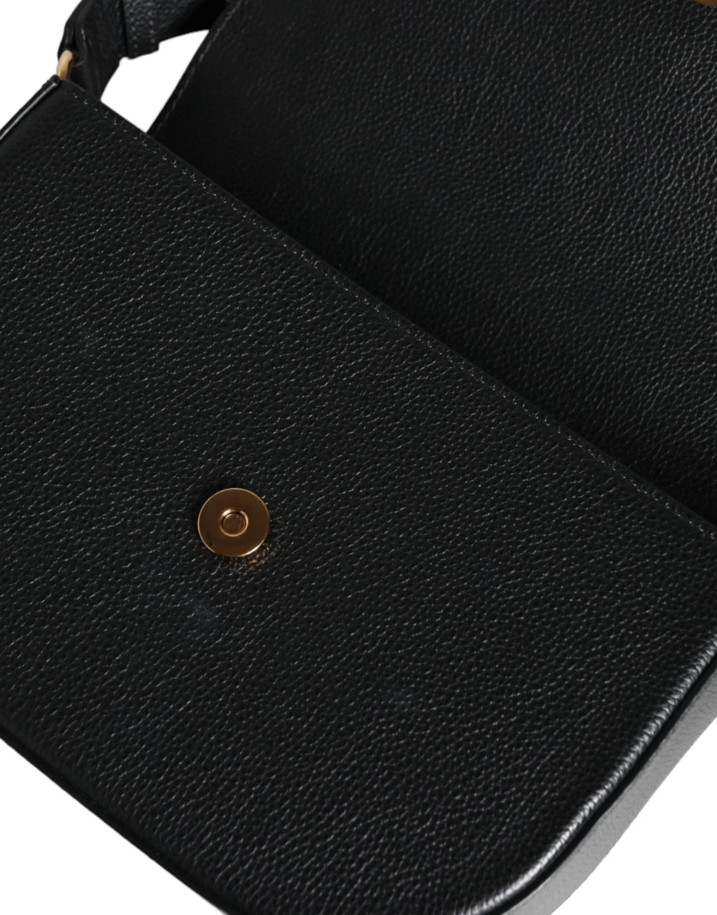 Detail of black textured leather designer handbag with gold snap closure from ONJEL Fashion Boutique