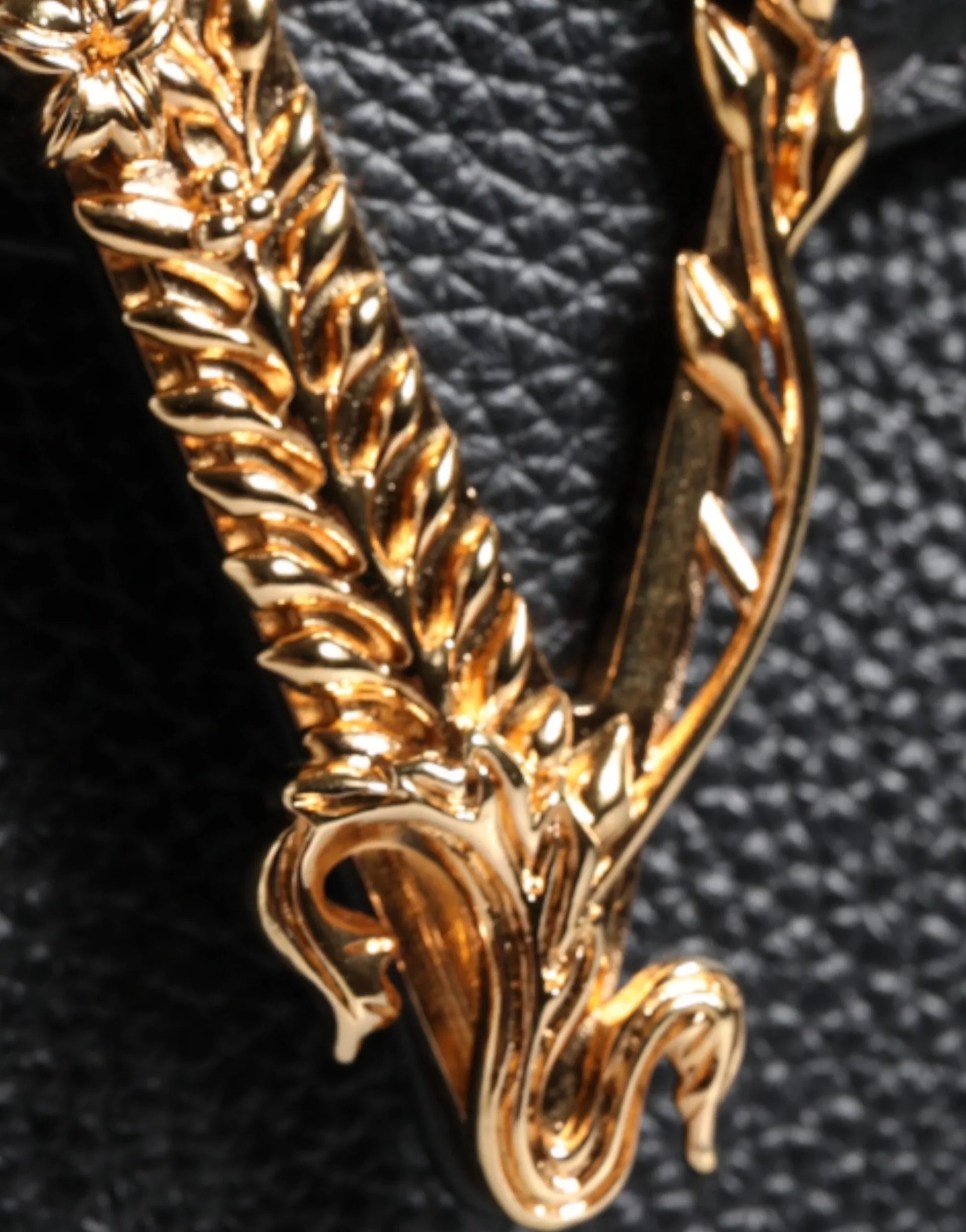 Gold ornate designer logo detail on textured black leather bag at ONJEL Fashion Boutique