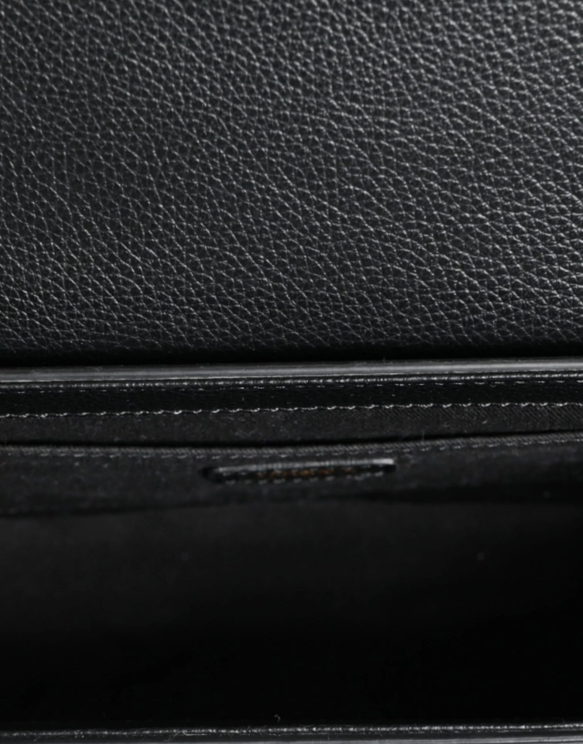 Close-up of premium black textured leather, detail of designer fashion accessory at ONJEL Boutique.